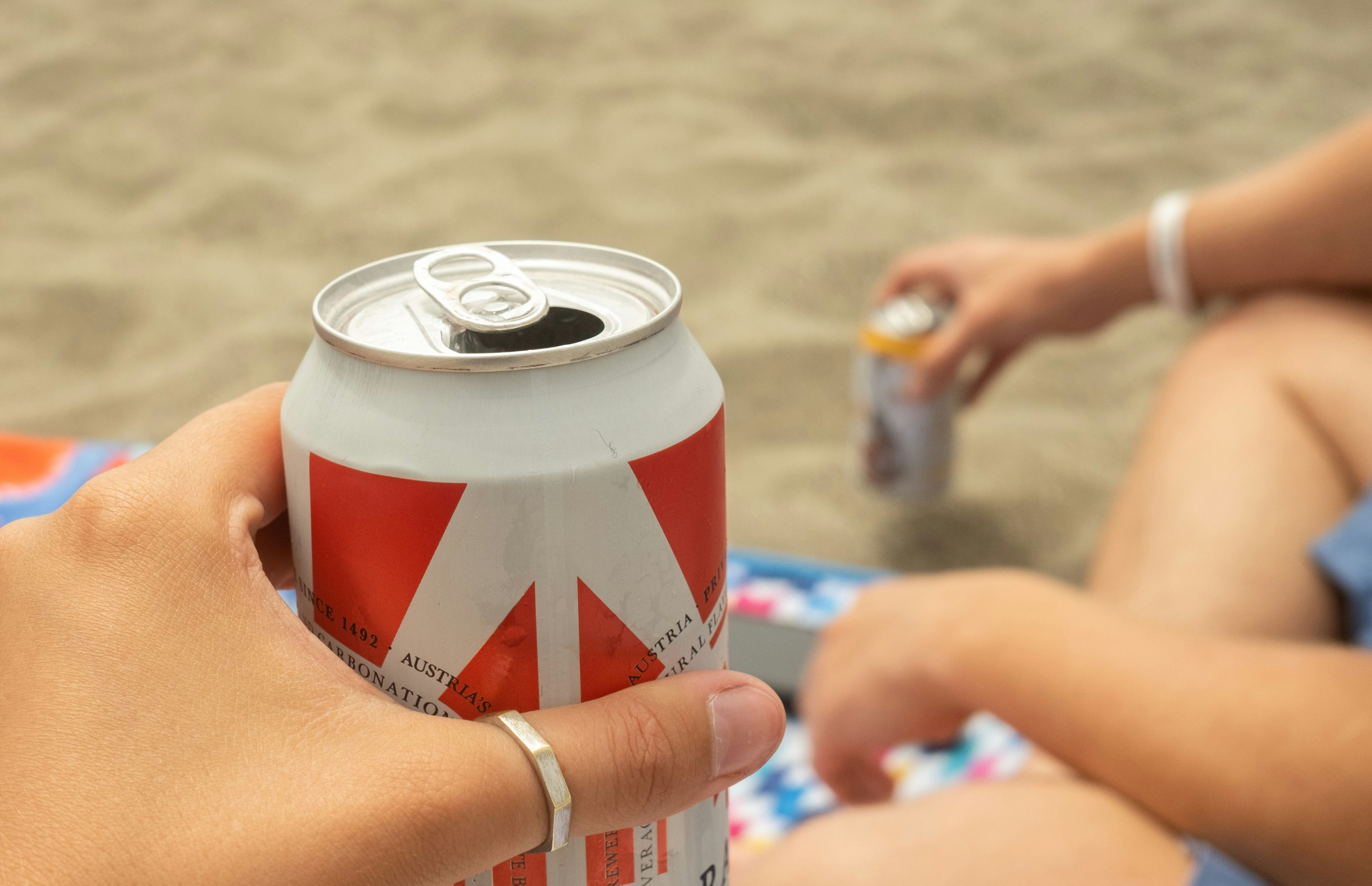 People drinking cans at the beach