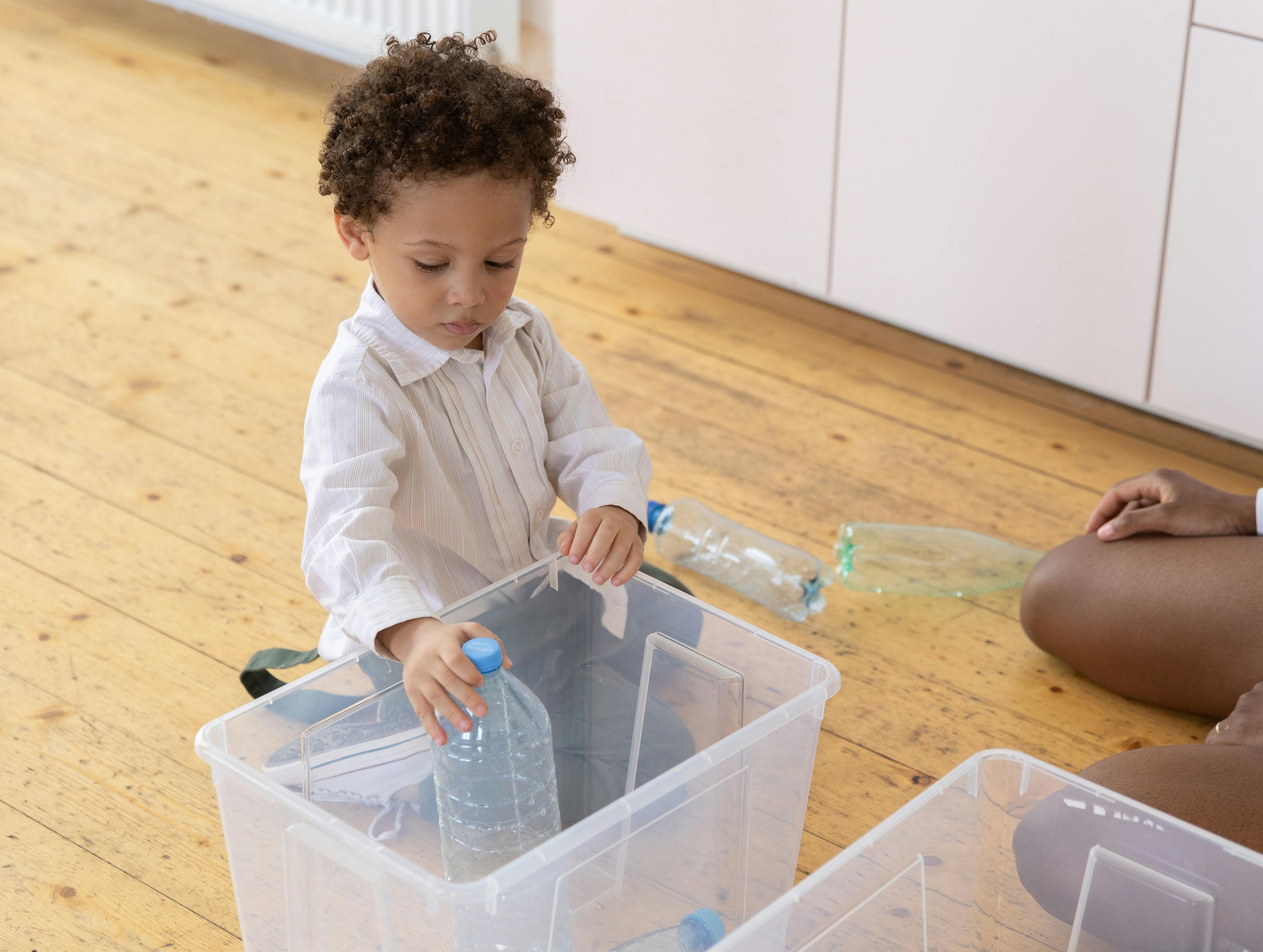 Kid throwing plastic bottle in box