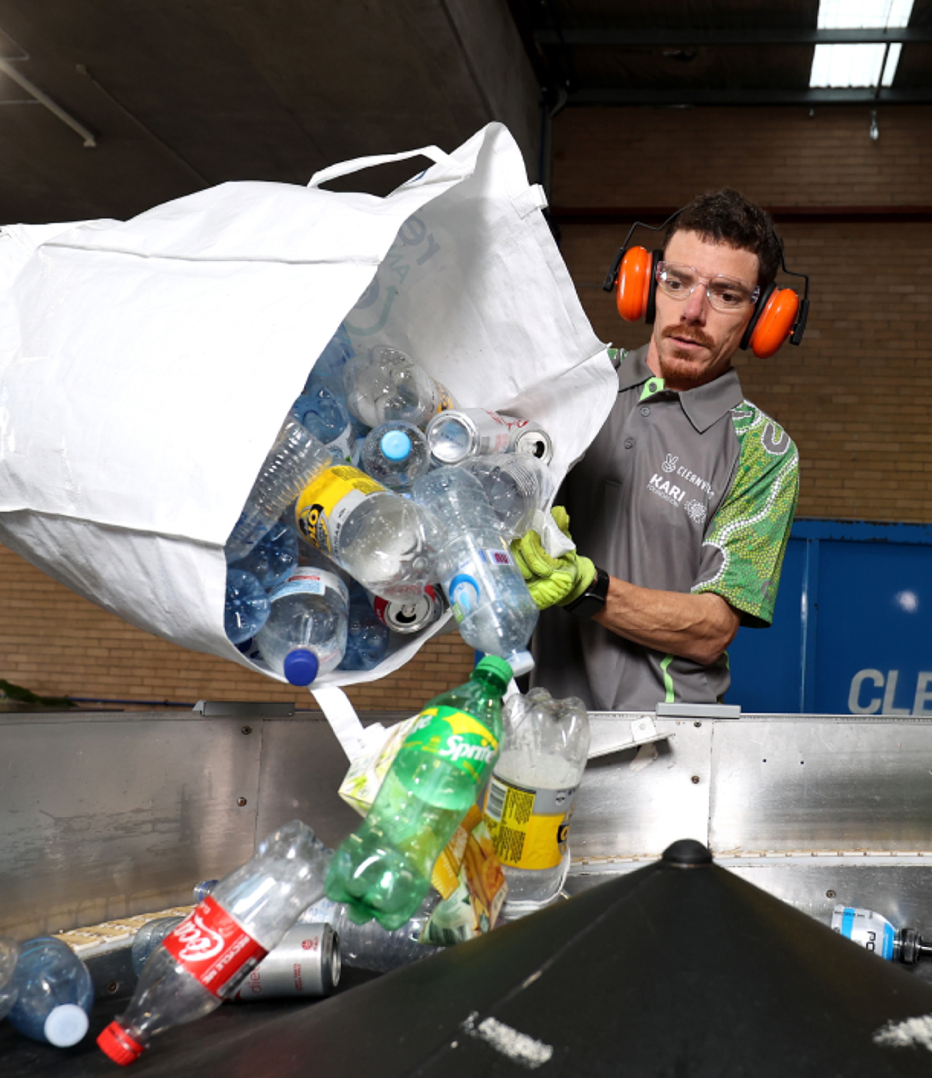 Man dumping recyclable drinks into marchine