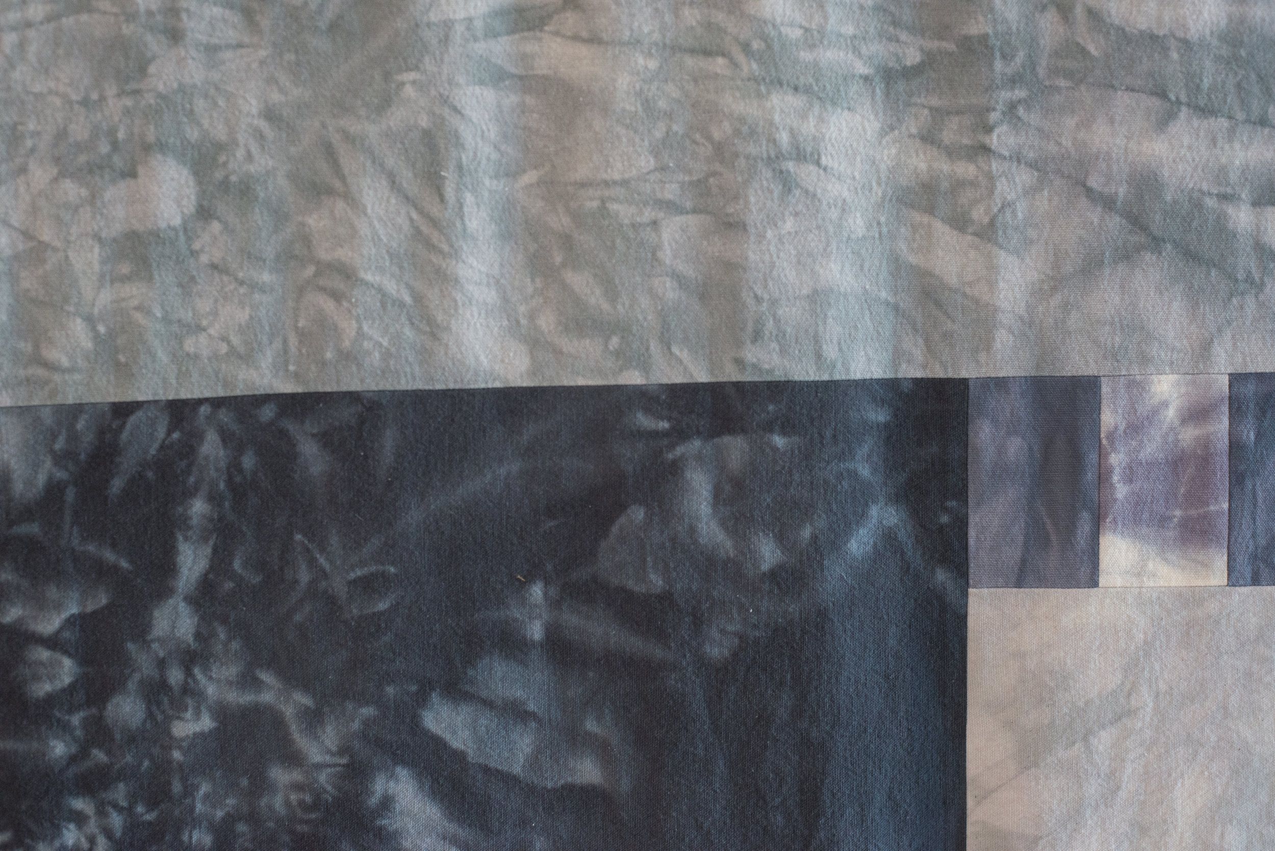 Abstract fabric collage with overlapping light and dark marbled rectangles
