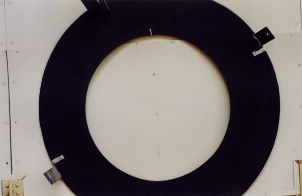 Large black circular ring mounted on a light-colored wall