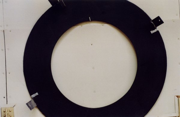 Large black circular ring mounted on a light-colored wall
