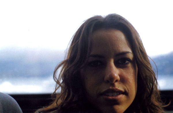 Woman looking at the camera with a blurred outdoor background