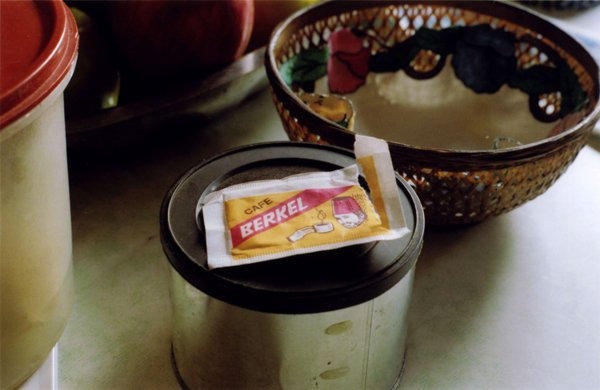 Single-serve packet labeled “Café Berkel” resting on a metal canister