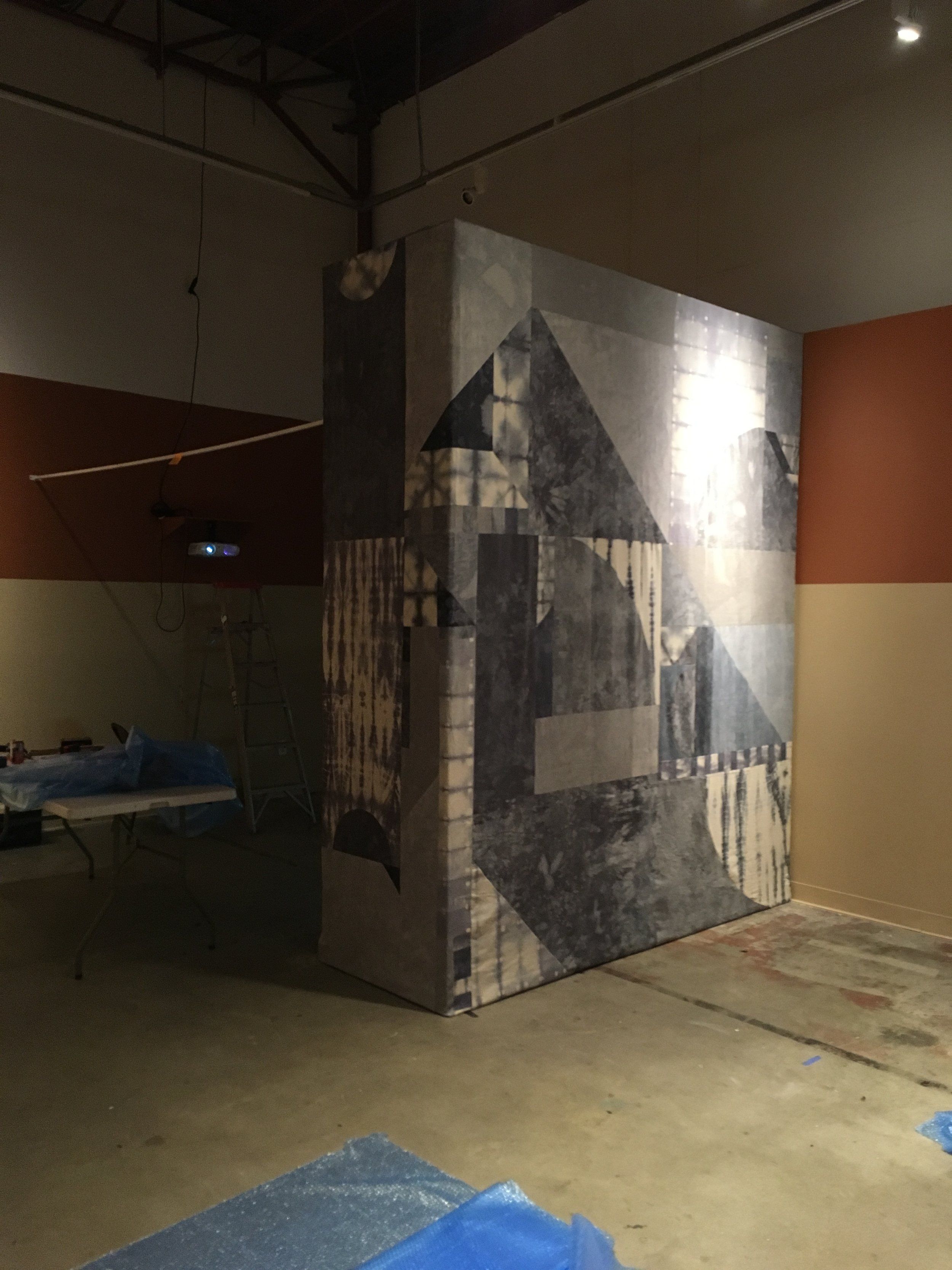 Large freestanding geometric mural installation in an unfinished gallery space