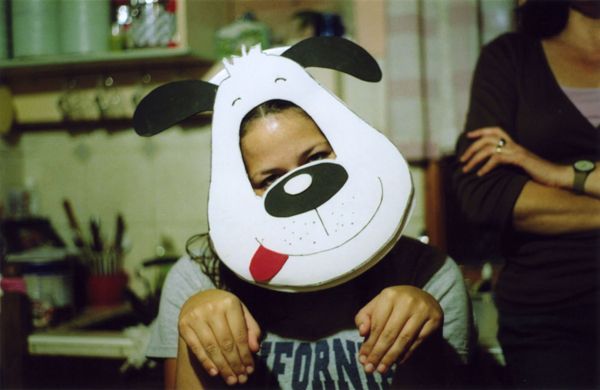 Person wearing a cartoon dog mask and posing with paws up
