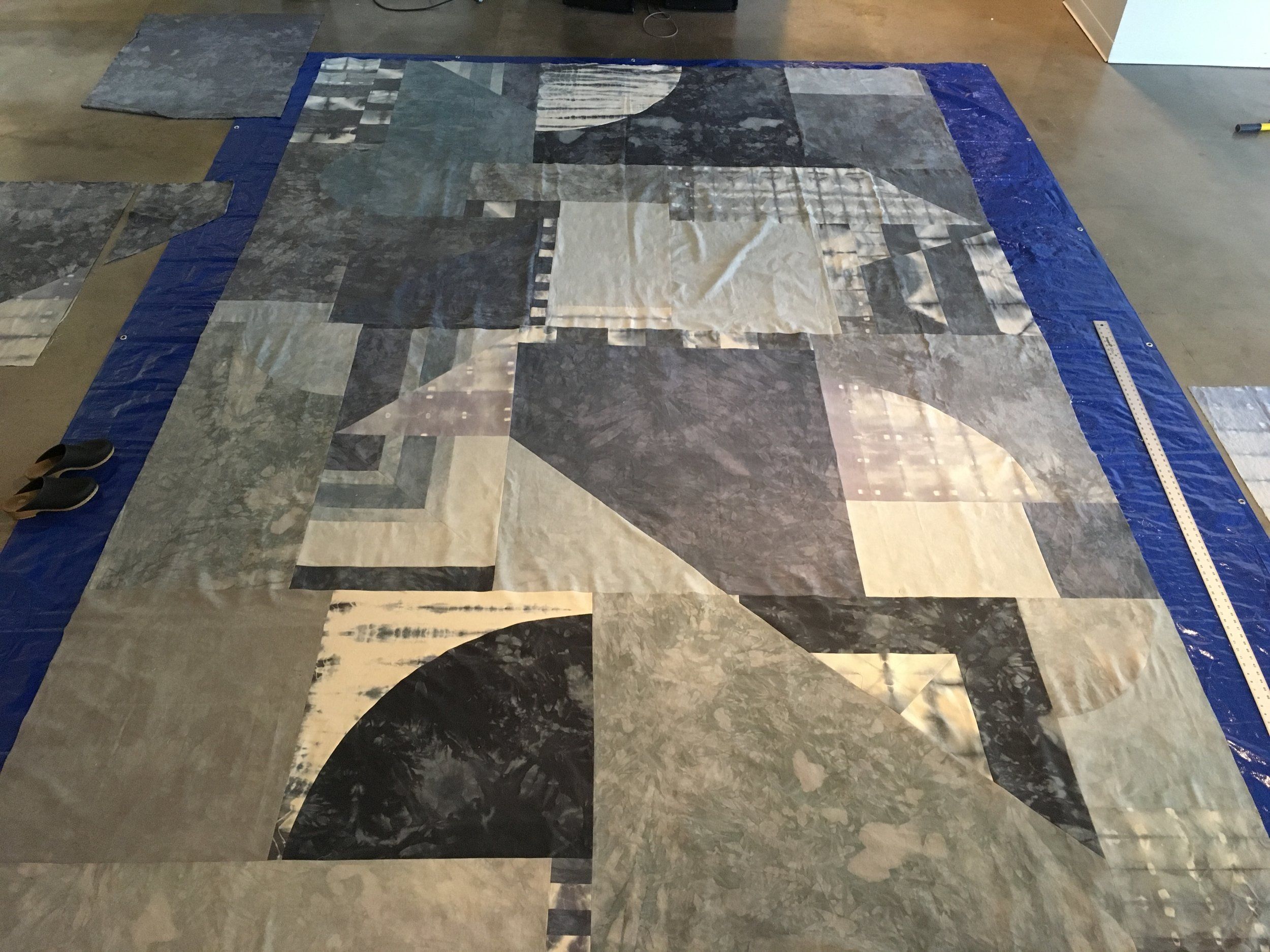 Large geometric patchwork textile laid out on a studio floor