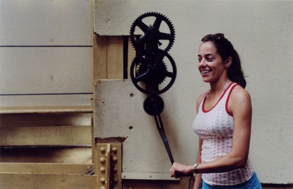 Woman operating a hand crank attached to exposed metal gears