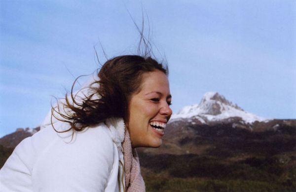 Smiling woman outdoors with snowy mountain peak in the background