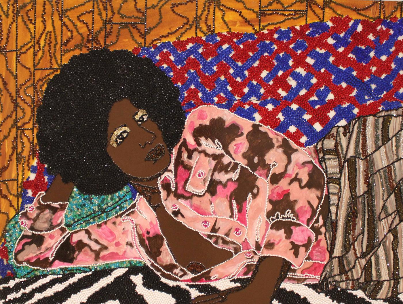 Woman with large, round afro laying on her side in a room full of mixed patterns