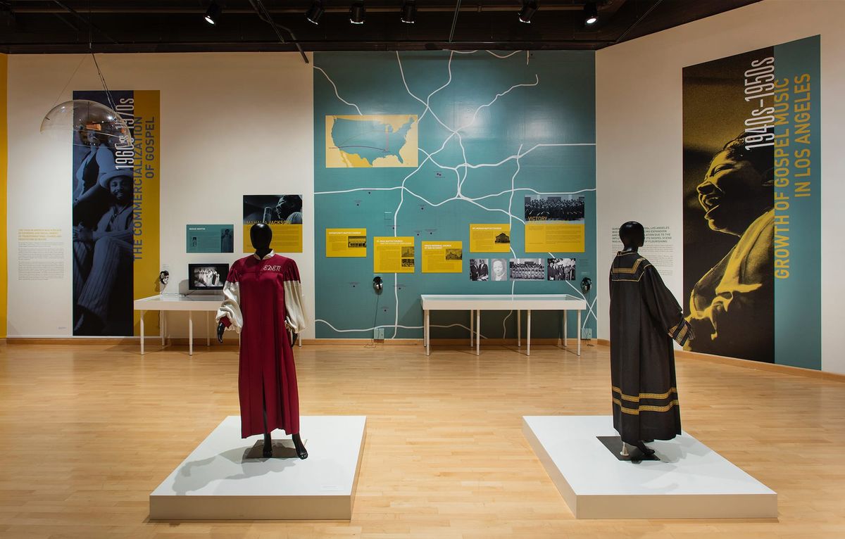 Installation view of gallery space with large scale images of gospel singers and supporting garments
