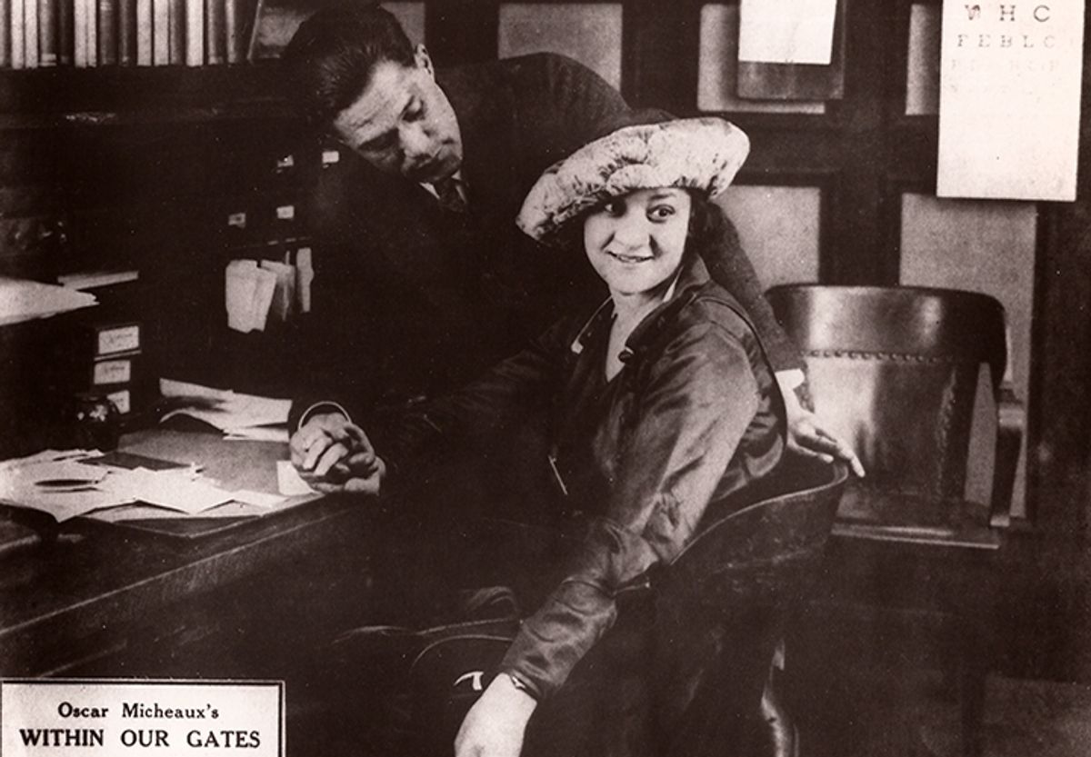 Black and white still of a man and woman in a 1920s office setting