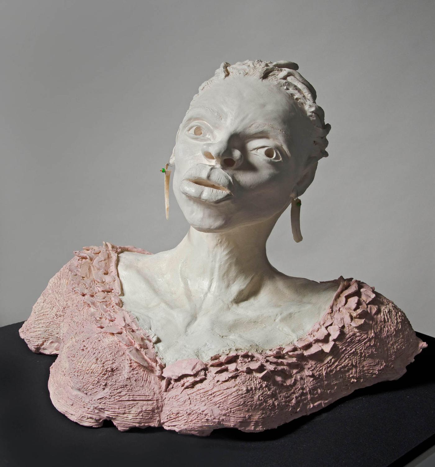 White ceramic bust of woman with wide eyes, short locs, and full lips