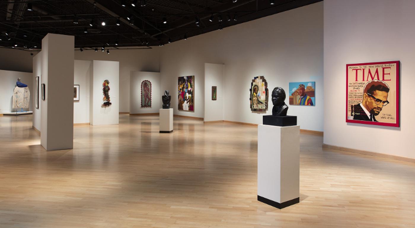 Installation view of busts, paintings, and considered open space for reflection