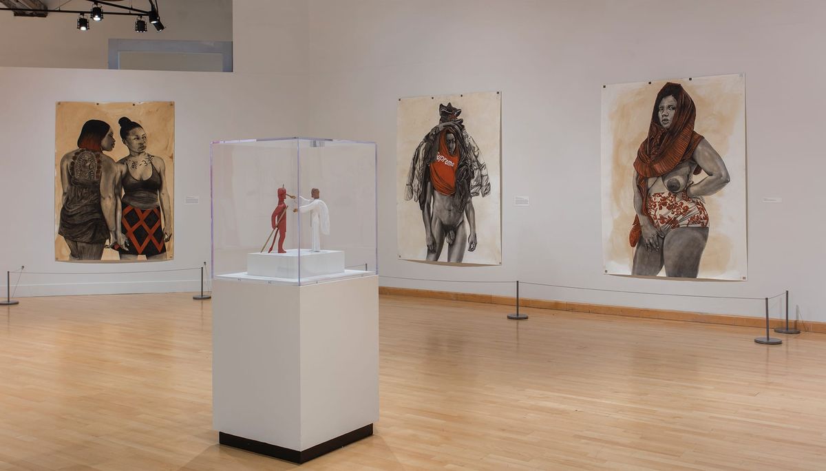 Installation view of paintings and sculpture under glass
