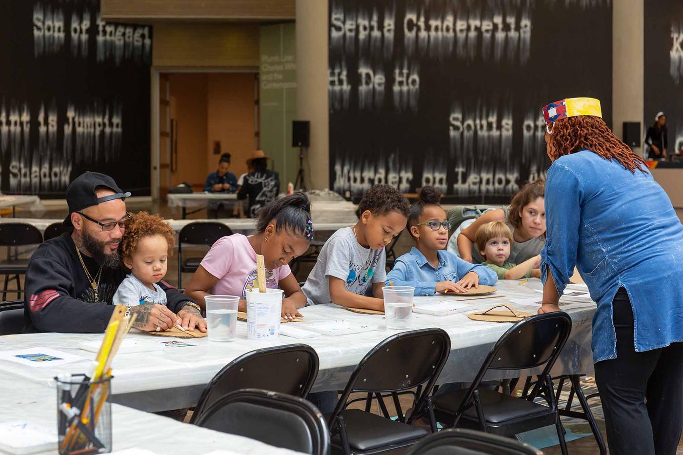 Children at long table participating in art workshop