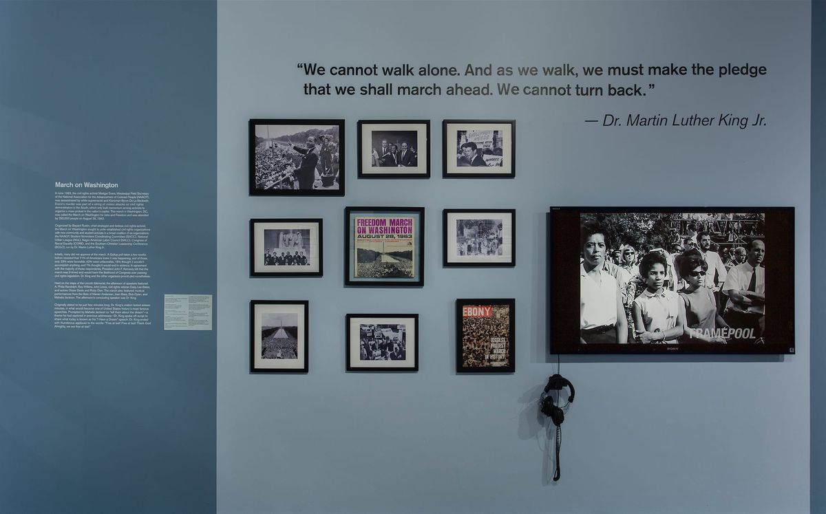 Installation view of monitor, photo elements, audio elements, and vitrines