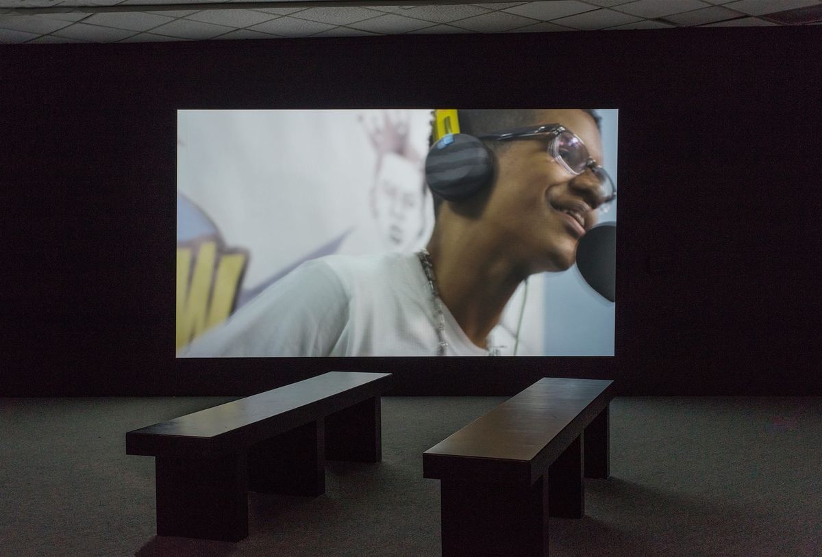 Installation view of large scale monitor and gallery seating