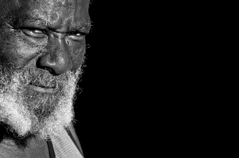 Portrait of man with white beard looking into sun