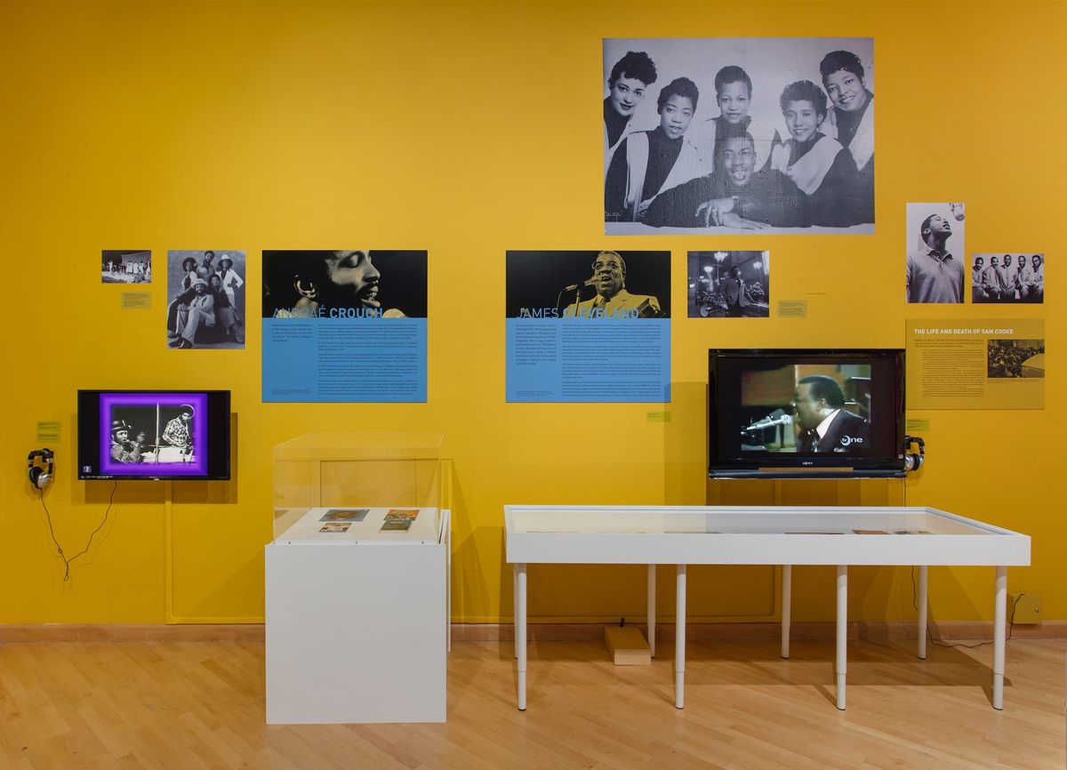 Installation view of monitor, photo elements, audio elements, and vitrines