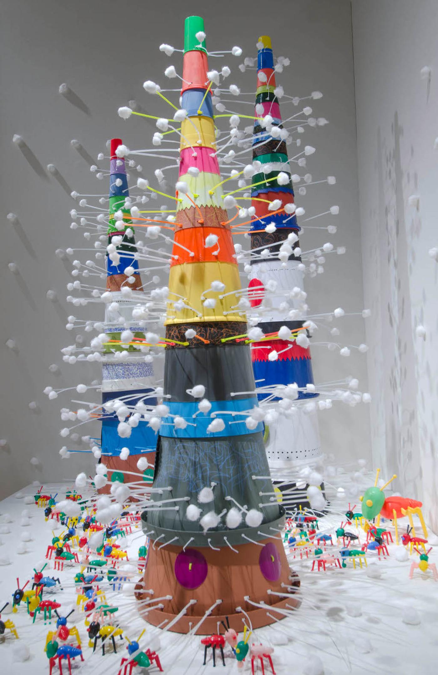 Resin and plastic assemblages that conjure ancient towers over a populated city