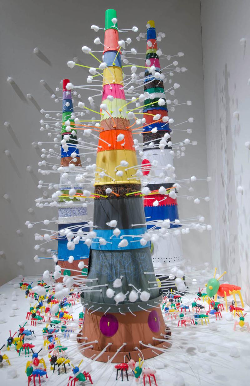 Resin and plastic assemblages that conjure ancient towers over a populated city
