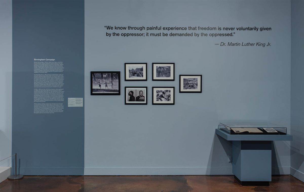 Installation view of photos and vitrine
