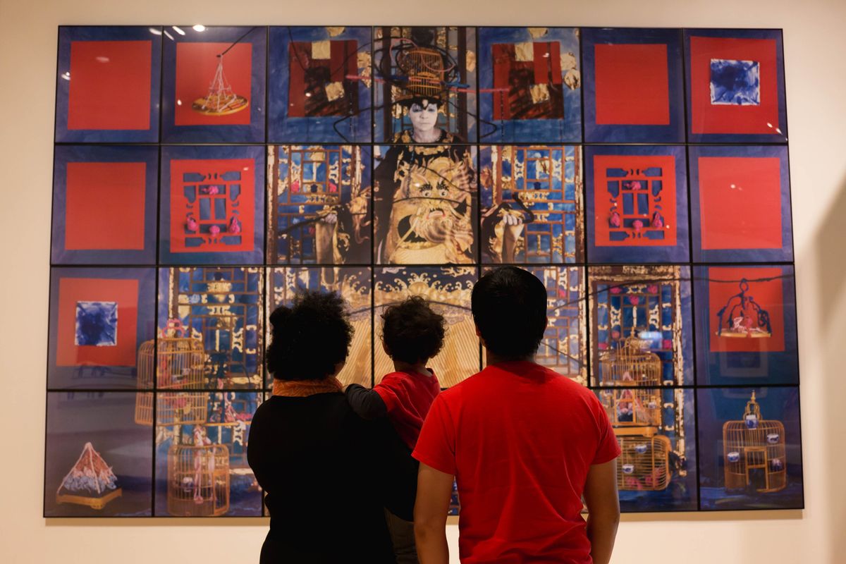 Family looks at a multi-panel, large-scale artwork