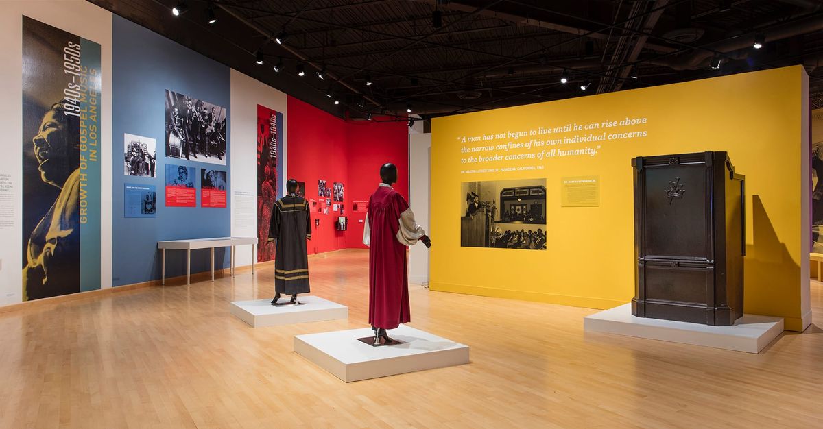 Installation view of choir robes, large scale photographs, and wall text