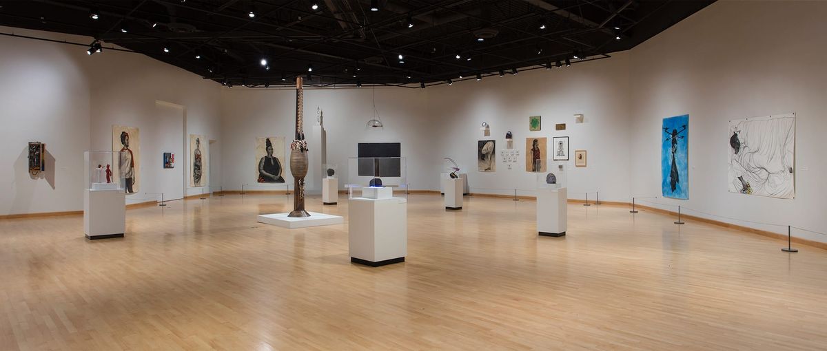 Installation view of large scale paintings, framed works, vitrines, and sculptures