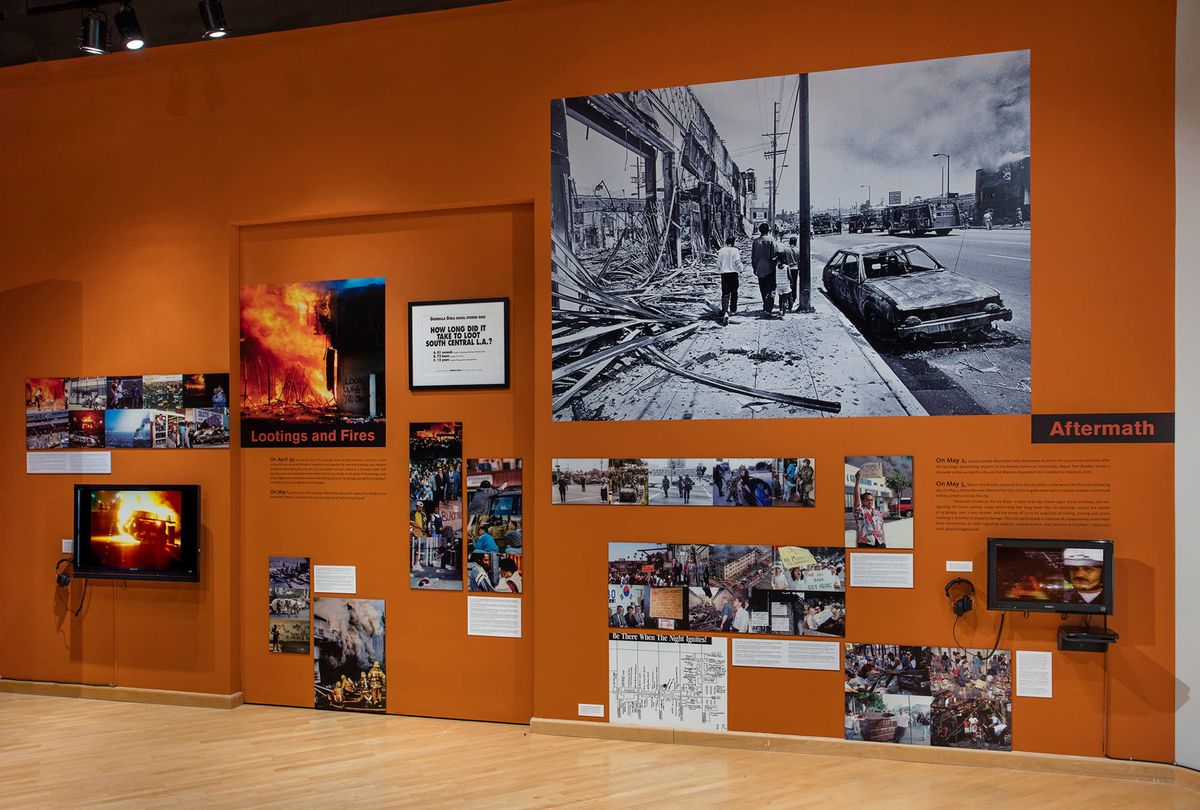 Exhibition view of photo collage and wall text, evocative of the frenetic energy that surrounded events of the day