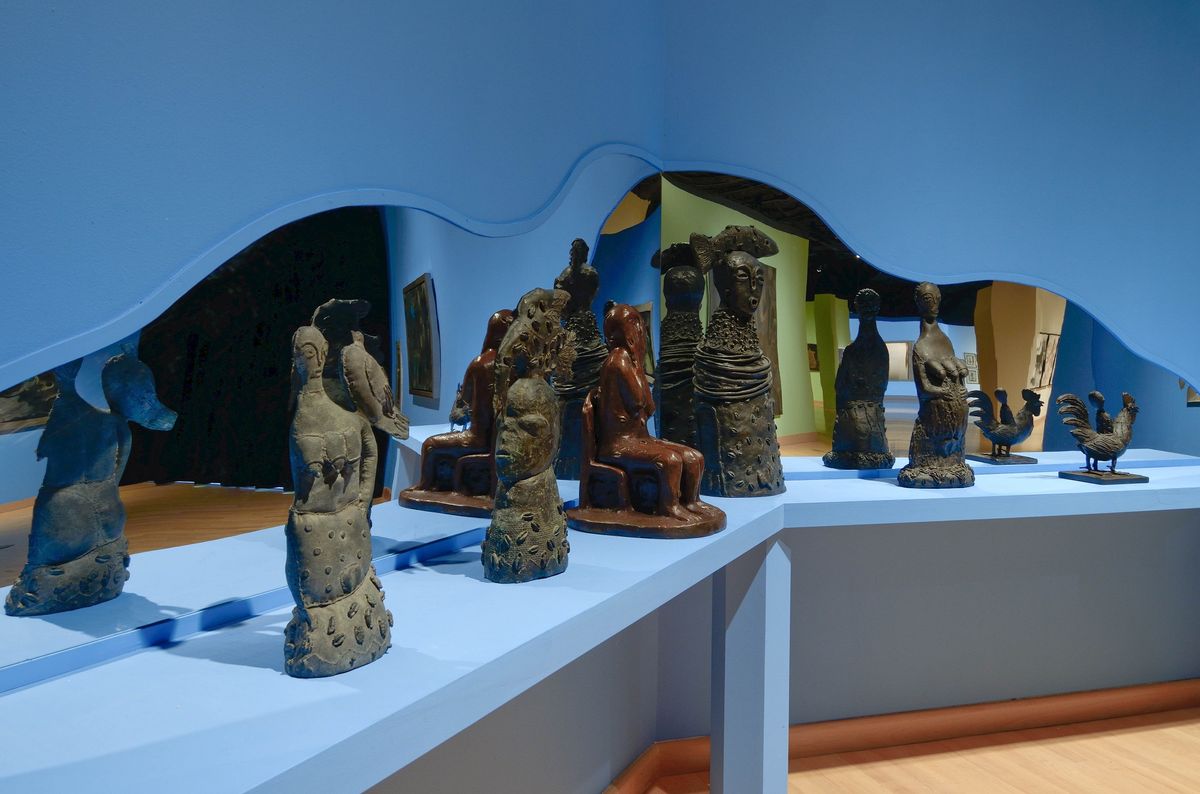 Installation view of space with blue walls and amorphic mirrors
