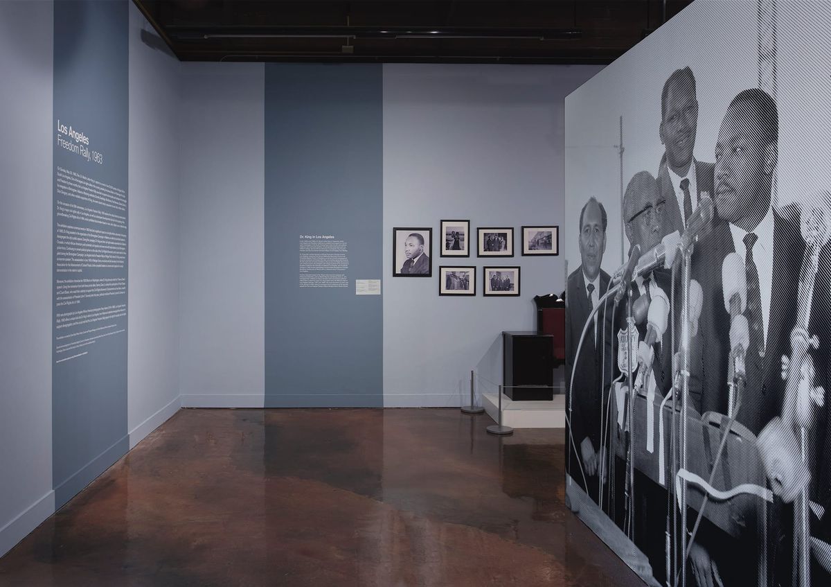 Large scale blow up of Dr. Martin Luther King Jr. at microphones with his political counterparts