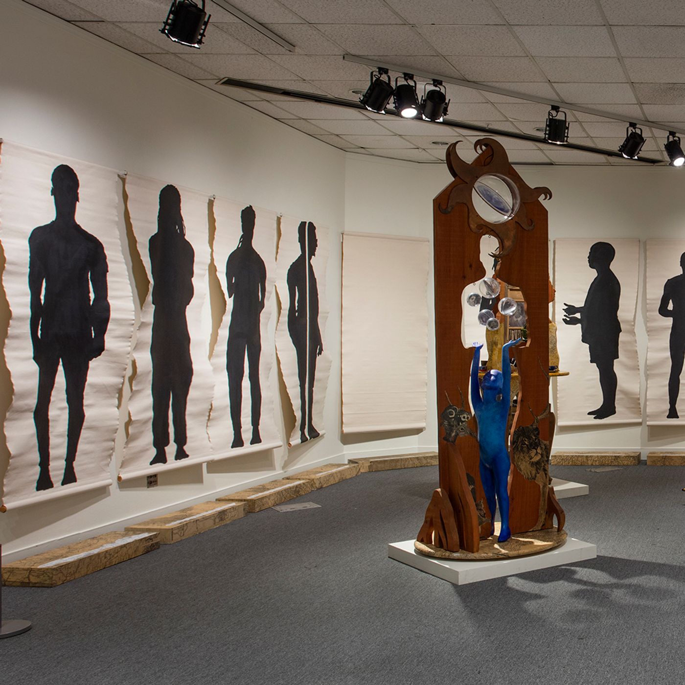 Installation view of life-size, full-length silhouettes