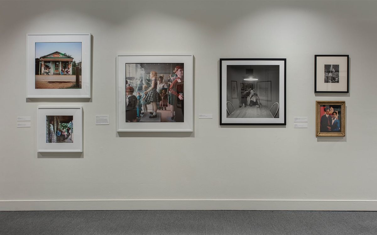 Installation view of framed photos and framed paintings