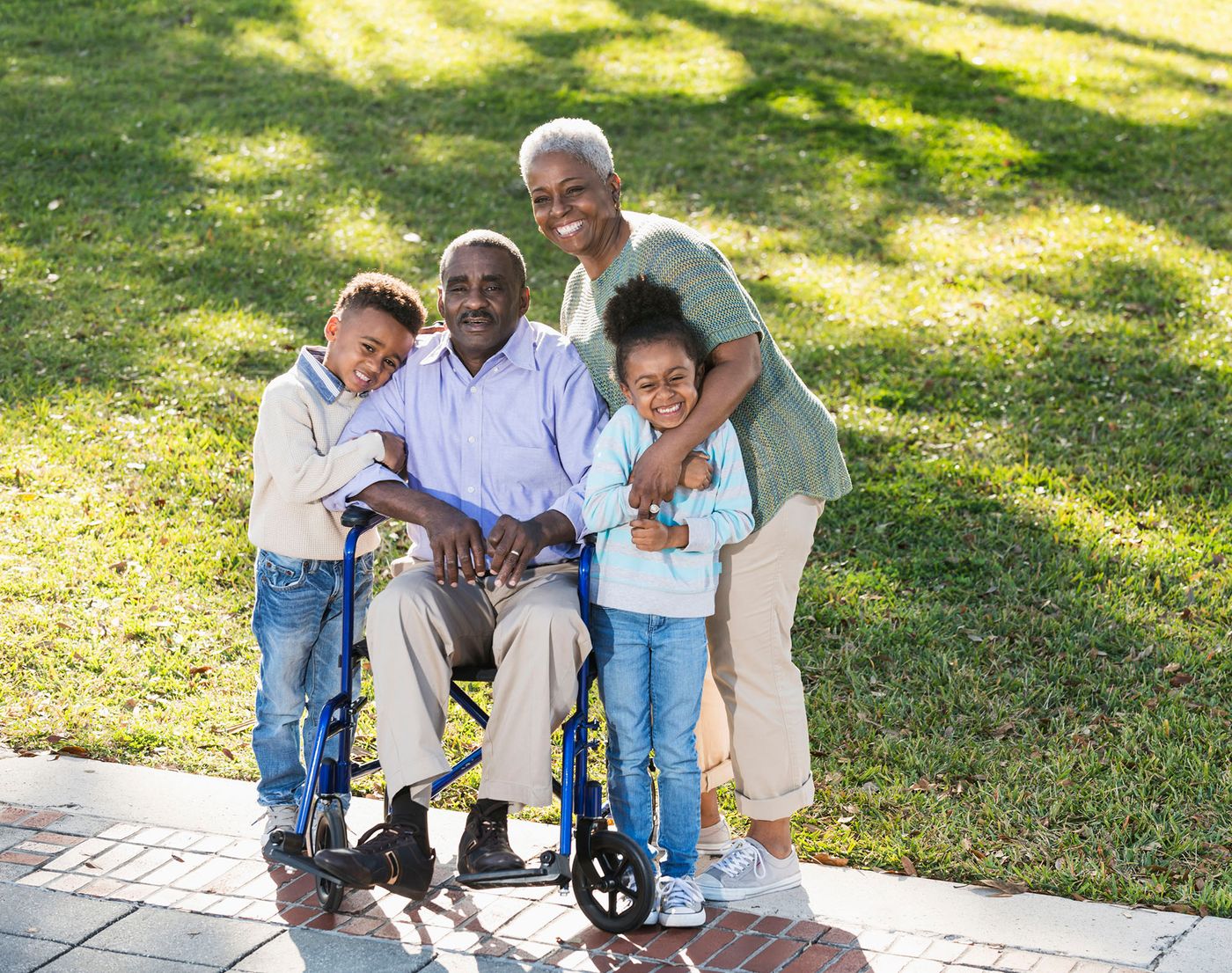 Family, with one using wheelchair, gathered for photo outdoors