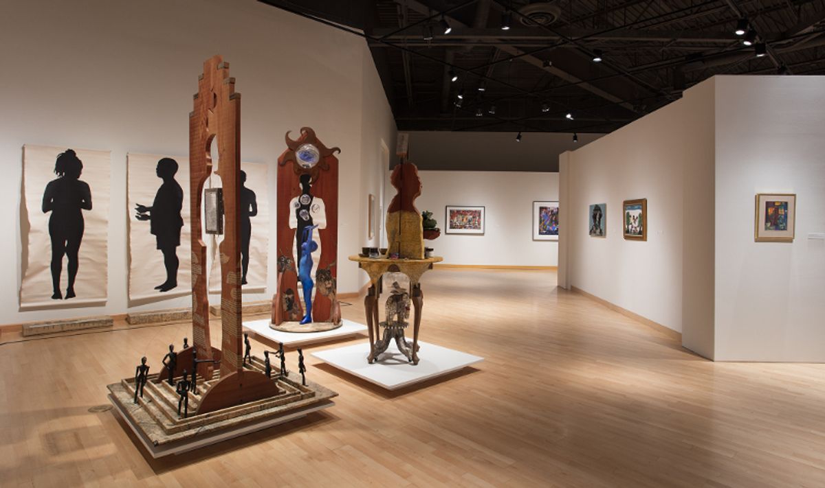 Installation view of framed works, wood sculpture, and large scale ink on paper