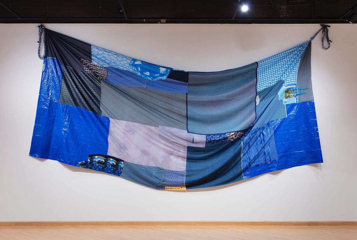 Blue patchwork made of furniture pads, blue plastic tarps, and long cuts of random blue fabrics