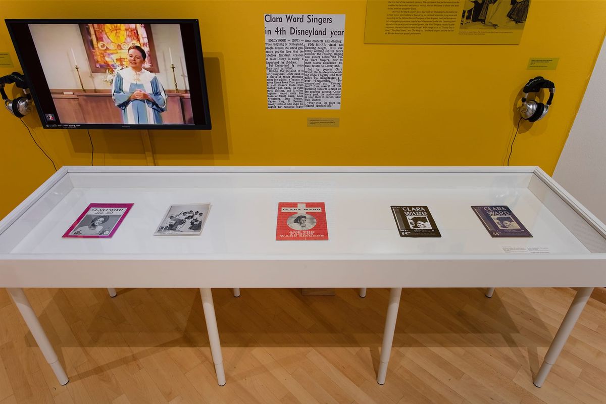 Installation view of monitor, photo elements, audio elements, and vitrines