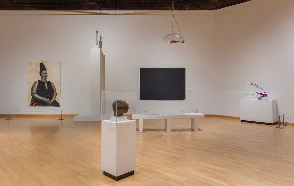 Installation view of sculptures, hanging objects, and large scale paintings