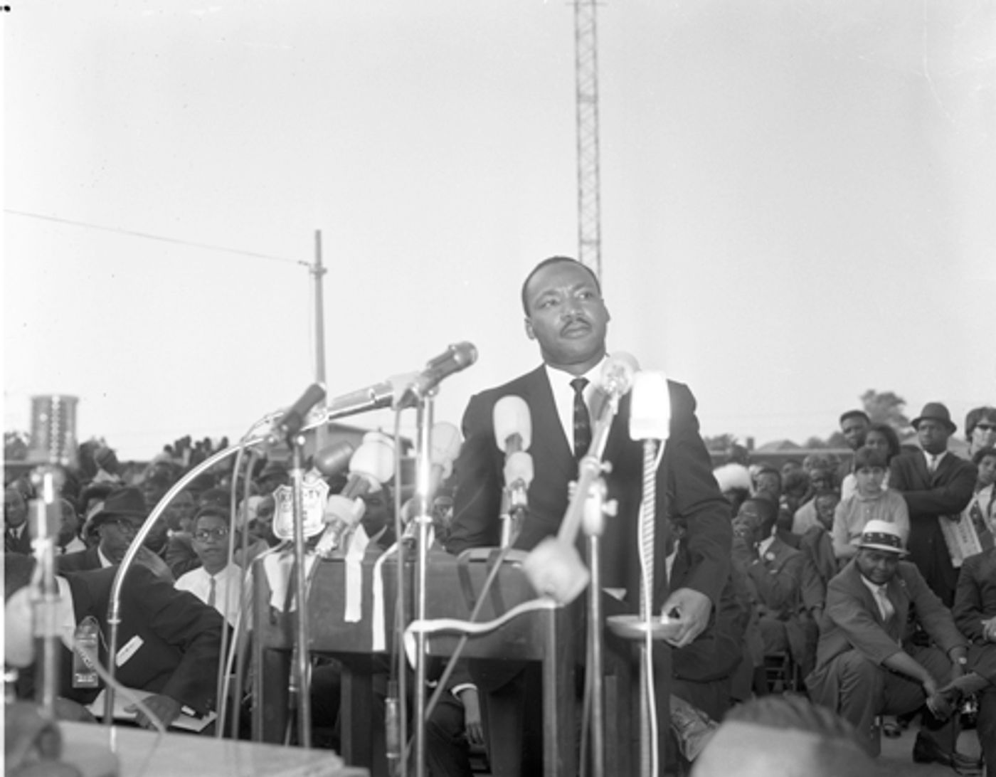 Dr. Martin Luther King Jr. behind a dozen microphones addressing large crowd