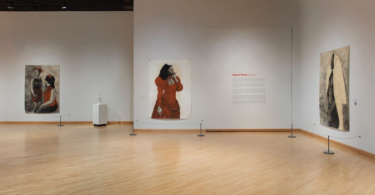 Installation view of woman in long sleeved red dress