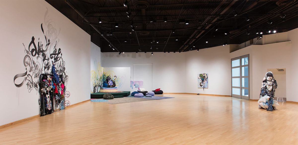 Installation view of sculpture, mixed media painting, and soft furniture space
