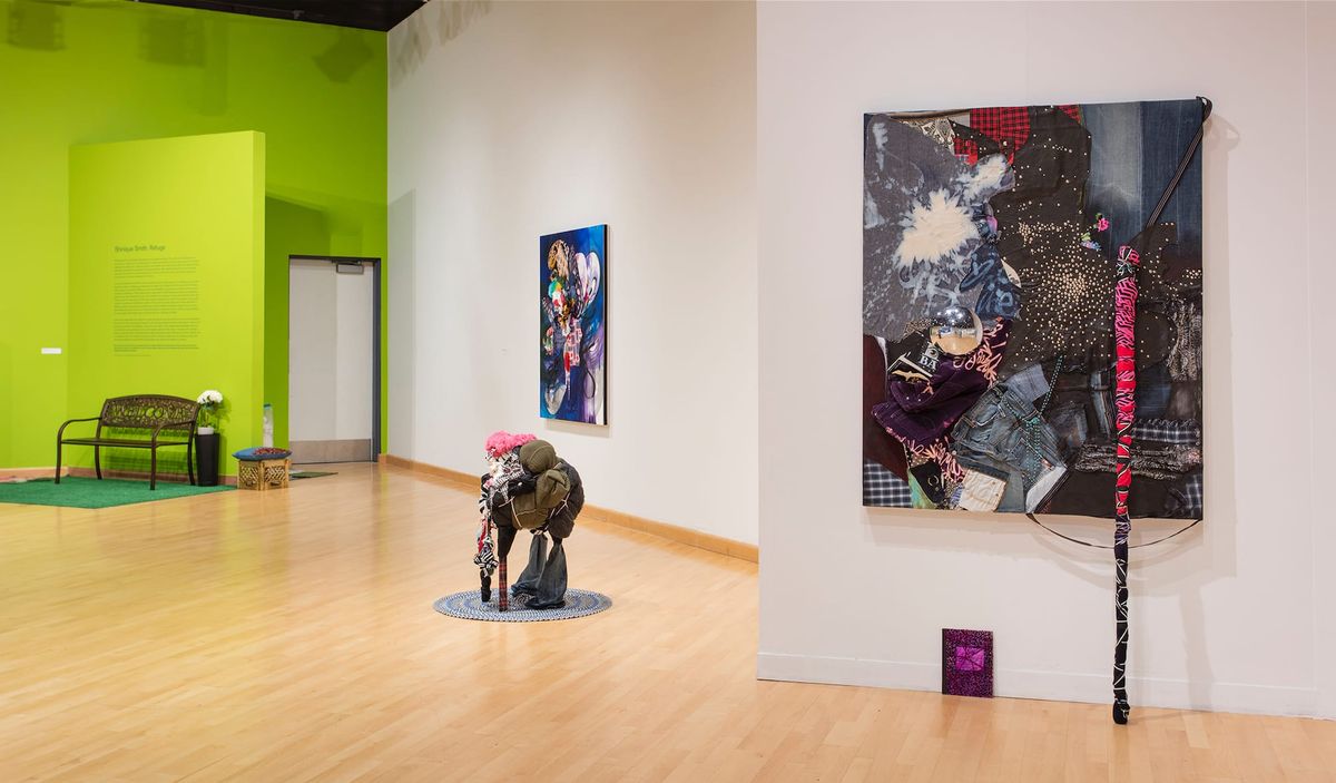 Installation view of bench, wall text, paintings, and sculptures