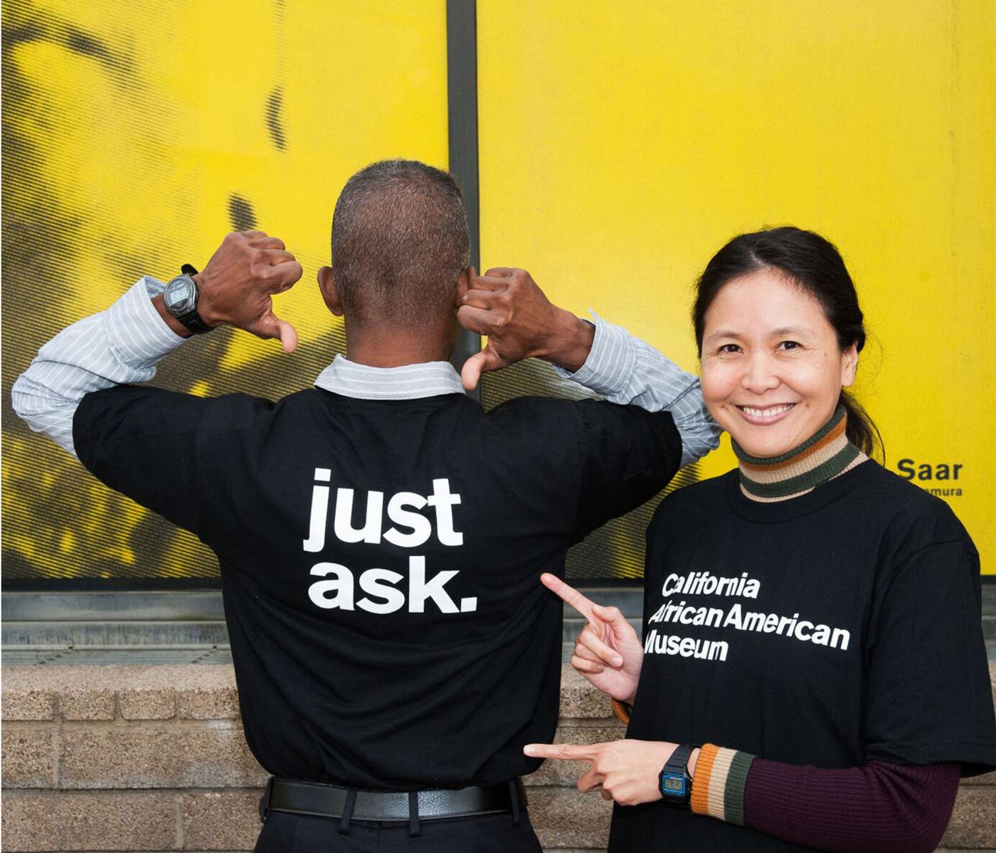 Staff members playfully showing off their CAAM work tees