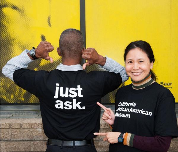 Staff members playfully showing off their CAAM work tees