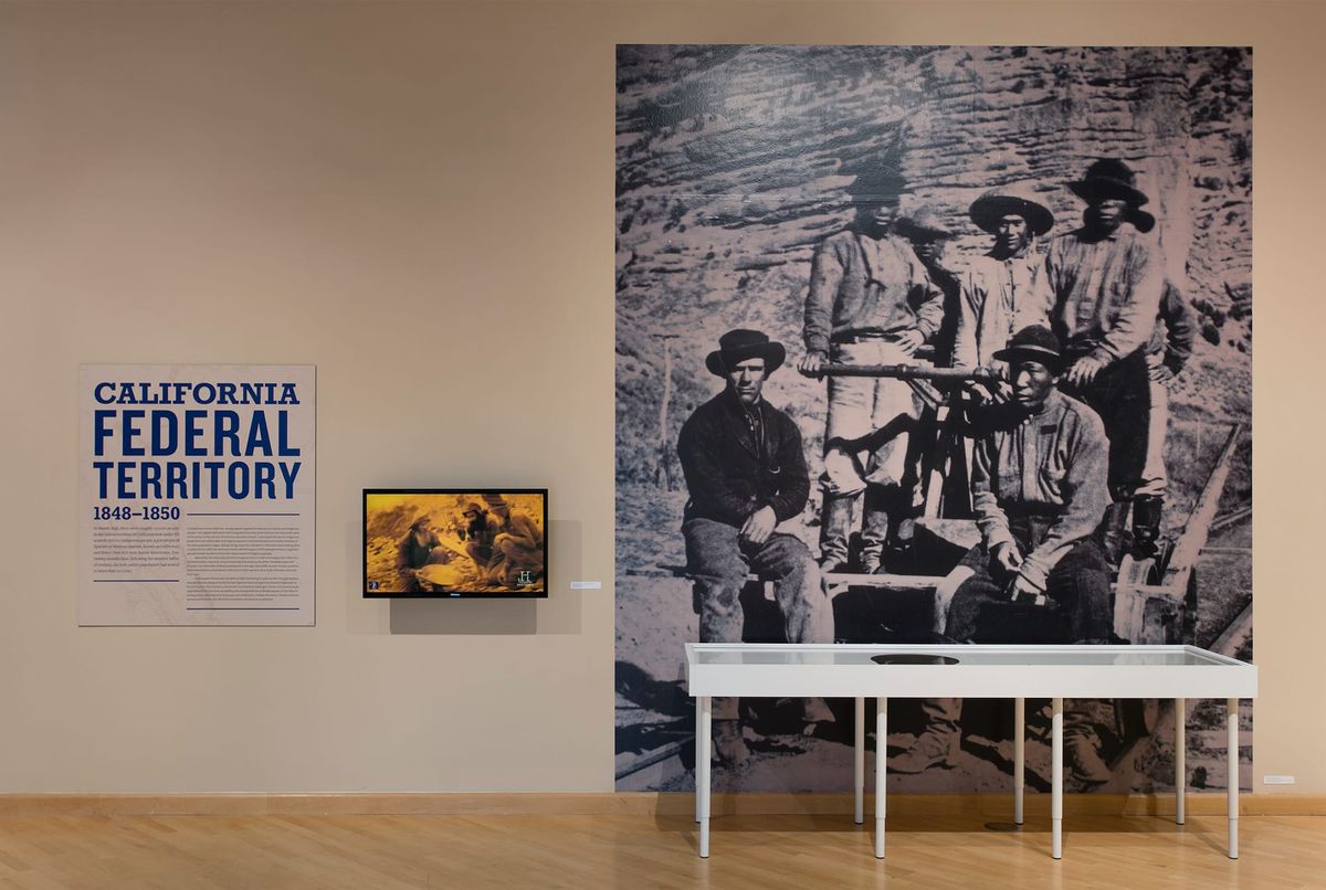 Installation view of wall text, monitor, and photograph