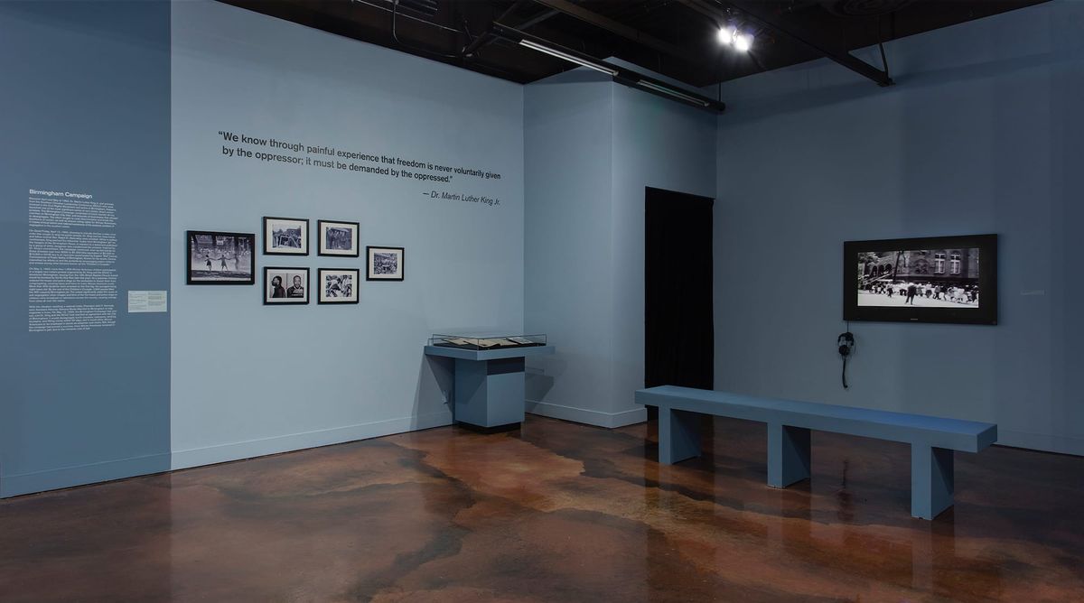 Installation view of monitor, photo elements, and vitrines