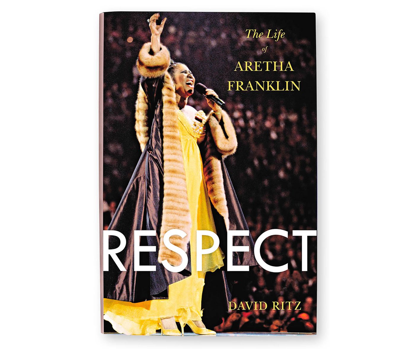 Aretha Franklin performing while wearing a yellow gown and a taffeta and mink coat