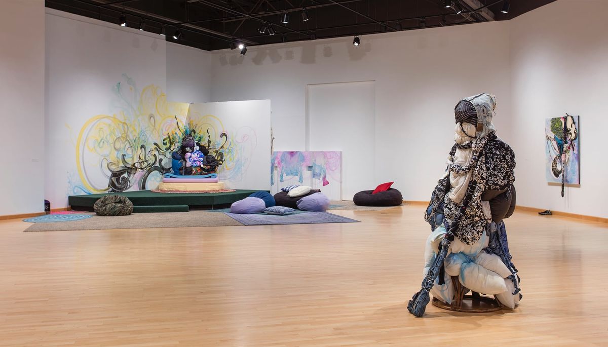 Installation view of sculpture and soft furnishings vignette